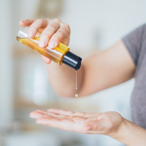 Massageoel in der Hand erwaermen